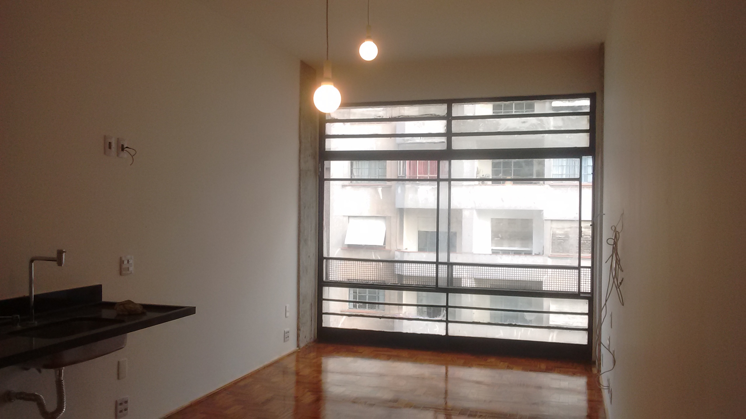 reforma quitinete kitnet kitenete piso taco restauro concreto aparente estrutura caixilho ferro preto manter iluminação lâmpada balão cozinha integrada