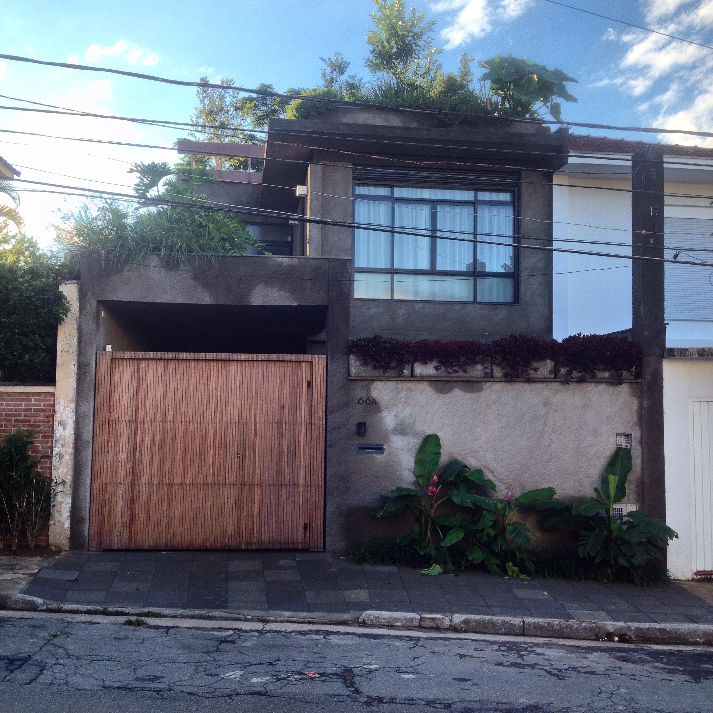 reforma construção obra projeto arquitetura casa vila nova conceição concreto aparente chapisco bananeira guaimbê caixilho preto alumínio portão madeira deck ripa jardim paisagismo estrutura metálica piso taco palito